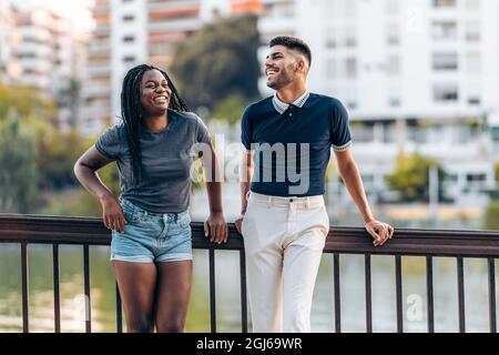 Zwei junge Menschen unterschiedlicher Ethnien lachen im Freien Stockfoto