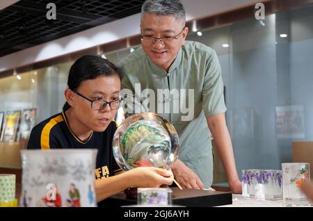 (210909) -- HENGSHUI, 9. September 2021 (Xinhua) -- Wang Ziyong (R) leitet Lehrlinge an, in einem Museum mit Innengemälden im Bezirk Taocheng der Stadt Hengshui, Provinz Hebei, im Norden Chinas, am 1. September 2021 Innenmalereien zu schaffen. Innenmalerei oder Innenmalerei ist eine traditionelle chinesische Kunstform. Es handelt sich ursprünglich um kleine Schnupftabakflaschen, die Bilder und Kalligrafie auf der Innenseite der Flasche gemalt haben. Snuff-Flaschenmalereien werden durch die Manipulation eines speziellen Pinsels durch den Flaschenhals hergestellt. Der Prozess der Malerei, der sich im Inneren völlig umgekehrt Stockfoto