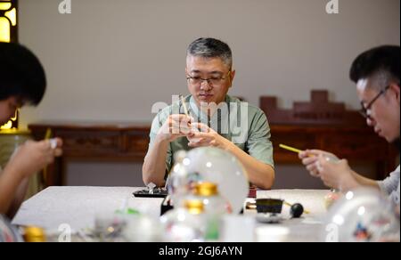 (210909) -- HENGSHUI, 9. September 2021 (Xinhua) -- Wang Ziyong und seine Lehrlinge schaffen Innenmalereien auf der Innenfläche von Schnupftabakflaschen in einem Museum mit Innenmalereien im Bezirk Taocheng der Stadt Hengshui, nordchinesische Provinz Hebei, 1. September 2021. Innenmalerei oder Innenmalerei ist eine traditionelle chinesische Kunstform. Es handelt sich ursprünglich um kleine Schnupftabakflaschen, die Bilder und Kalligrafie auf der Innenseite der Flasche gemalt haben. Snuff-Flaschenmalereien werden durch die Manipulation eines speziellen Pinsels durch den Flaschenhals hergestellt. Der Prozess der Malerei, whi Stockfoto
