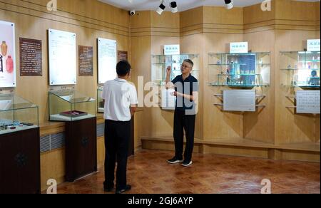 (210909) -- HENGSHUI, 9. September 2021 (Xinhua) -- Wang Ziyong (R) stellt in einem Museum mit Innengemälden im Bezirk Taocheng der Stadt Hengshui, nordchinesische Provinz Hebei, am 1. September 2021 Innenmalereien vor. Innenmalerei oder Innenmalerei ist eine traditionelle chinesische Kunstform. Es handelt sich ursprünglich um kleine Schnupftabakflaschen, die Bilder und Kalligrafie auf der Innenseite der Flasche gemalt haben. Snuff-Flaschenmalereien werden durch die Manipulation eines speziellen Pinsels durch den Flaschenhals hergestellt. Der Prozess des Malens, der in der Flasche vollständig umgekehrt ist, erfordert Stockfoto