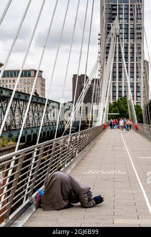 Eine Frau, die auf den Golden Jubilee Bridges, London, Großbritannien, bettelt Stockfoto