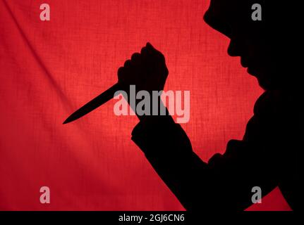 Mann mit einer Messersilhouette. Halloween und Gewalt Konzept Stockfoto