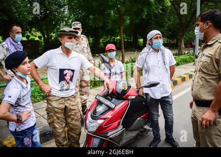 Neu-Delhi, Indien. September 2021. Ein afghanischer Flüchtling, der ein T-Shirt mit einem Bild des ehemaligen ermordeten Mudschaheddin-Kommandanten Ahmad Shah Massoud trägt, spricht mit einem Polizisten, nachdem ihnen die Erlaubnis verweigert wurde, in der Nähe der pakistanischen Botschaft in Neu-Delhi einen Protest abzuhalten. Kredit: SOPA Images Limited/Alamy Live Nachrichten Stockfoto