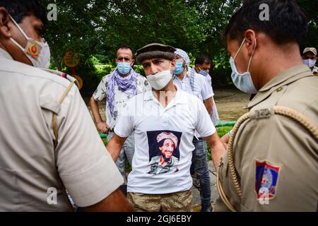 Neu-Delhi, Indien. September 2021. Ein afghanischer Flüchtling, der ein T-Shirt mit einem Bild des ehemaligen ermordeten Mudschaheddin-Kommandanten Ahmad Shah Massoud trägt, spricht mit einem Polizisten, nachdem ihnen die Erlaubnis verweigert wurde, in der Nähe der pakistanischen Botschaft in Neu-Delhi einen Protest abzuhalten. Kredit: SOPA Images Limited/Alamy Live Nachrichten Stockfoto