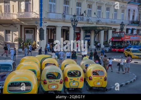 Gelbe, dreirädrige Taxis, die in der Altstadt von Havanna, La Habana Vieja, Kuba, geparkt sind Stockfoto