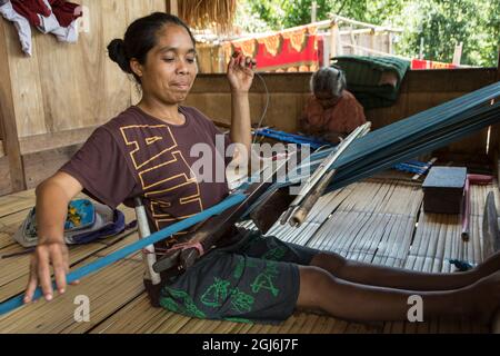 Frau, die im traditionellen Dorf Bena .Flores Island, East Nusa Tenggare, Indonesien, ein ikat-Tuch webt. Stockfoto