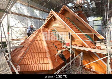 Stiege, Deutschland. September 2021. Die restlichen Arbeiten werden auf dem Dach der Stabkirche von Arbeitern durchgeführt. Die Holzkirche im norwegischen Drachenstil, die in Deutschland einzigartig ist, wurde aus dem Wald im Harz nach Stiege verlegt. In wenigen Wochen sollten der Umzug und der Wiederaufbau abgeschlossen sein. Quelle: Matthias Bein/dpa-Zentralbild/ZB/dpa/Alamy Live News Stockfoto