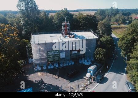 Stiege, Deutschland. September 2021. Handwerker platzieren die Turmdekoration auf der Stabkirche. Die Holzkirche im norwegischen Drachenstil, die in Deutschland einzigartig ist, wurde aus dem Wald im Harz nach Stiege verlegt. In wenigen Wochen sollten der Umzug und der Wiederaufbau abgeschlossen sein. Quelle: Matthias Bein/dpa-Zentralbild/ZB/dpa/Alamy Live News Stockfoto