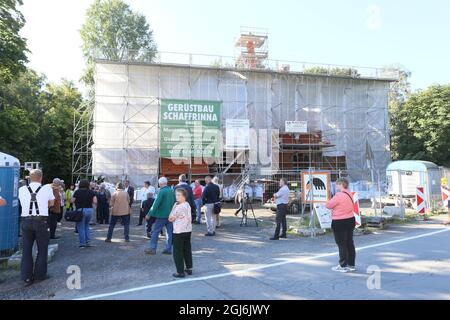 Stiege, Deutschland. September 2021. Handwerker platzieren die Turmdekoration auf der Stabkirche. Die Holzkirche im norwegischen Drachenstil, die in Deutschland einzigartig ist, wurde aus dem Wald im Harz nach Stiege verlegt. In wenigen Wochen sollten der Umzug und der Wiederaufbau abgeschlossen sein. Quelle: Matthias Bein/dpa-Zentralbild/ZB/dpa/Alamy Live News Stockfoto