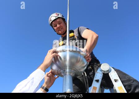 Stiege, Deutschland. September 2021. Der Handwerker Thomas Müller installiert die Turmdekoration an der Stabkirche. Die Holzkirche im norwegischen Drachenstil, die in Deutschland einzigartig ist, wurde aus dem Wald im Harz nach Stiege verlegt. In wenigen Wochen sollten der Umzug und der Wiederaufbau abgeschlossen sein. Quelle: Matthias Bein/dpa-Zentralbild/ZB/dpa/Alamy Live News Stockfoto