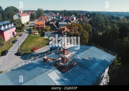 Stiege, Deutschland. September 2021. Handwerker platzieren die Turmdekoration auf der Stabkirche. Die Holzkirche im norwegischen Drachenstil, die in Deutschland einzigartig ist, wurde aus dem Wald im Harz nach Stiege verlegt. In wenigen Wochen sollten der Umzug und der Wiederaufbau abgeschlossen sein. Quelle: Matthias Bein/dpa-Zentralbild/ZB/dpa/Alamy Live News Stockfoto