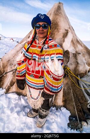Baker Lake, Nunavut, Kanada. Inuit Frau trägt zeremoniellen Amauti (Parka). Handgefertigt aus Karibuhaut und Perlen. Stehen vor dem traditionellen carib Stockfoto