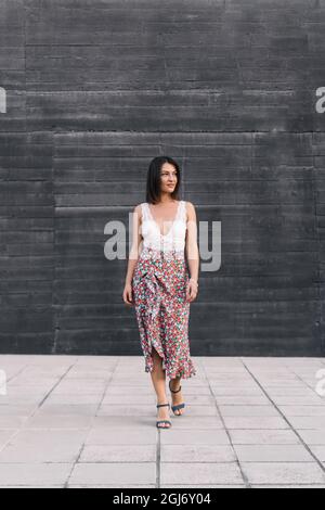 Brunette Frau in stilvollen Sommerkleidung zu Fuß im Freien auf der Straße. Stockfoto