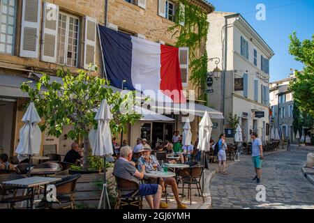 Kleine französische Dorfcafés mit französischer Flagge in der Provence in Südfrankreich. Stockfoto