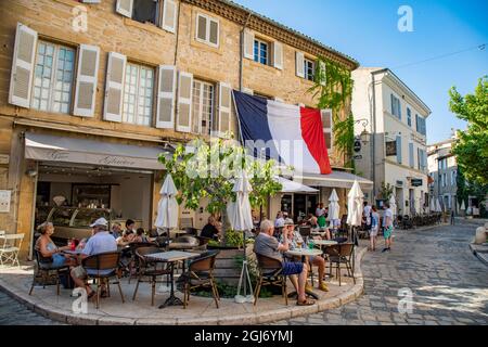 Kleine französische Dorfcafés mit französischer Flagge in der Provence in Südfrankreich. Stockfoto