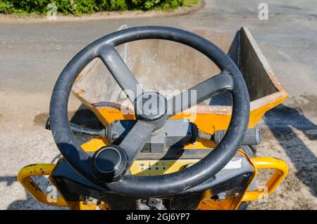 Fahren eines gelben Mini-Kipper entlang einer Farmstraße. Stockfoto