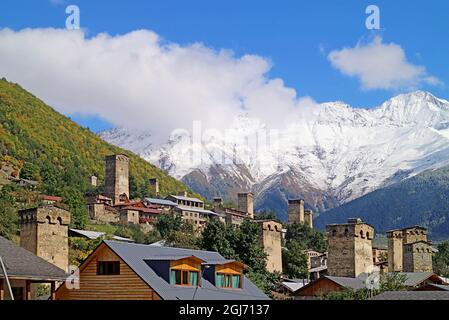 Erstaunliche mittelalterliche Swan Tower-Häuser in der Stadt Mestia mit schneebedeckten Kaukasus-Berg im Hintergrund, Svaneti Region von Georgien Stockfoto