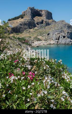 Griechenland, Rhodos. St. Paul's Bay mit der Akropolis von Lindos in der Ferne mit dem Tempel der Athene Lindia. Stockfoto