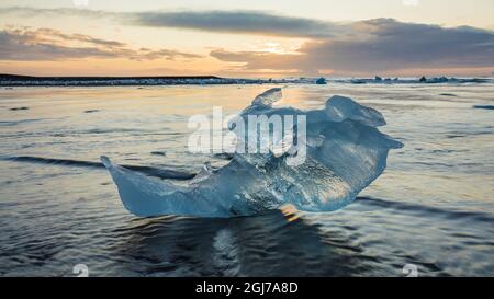Europa, Island. Das Morgenlicht leuchtet auf Eisbrocken am Diamond Beach in der Nähe der Gletscherlagune Jokulsarlon an der Südküste. Stockfoto