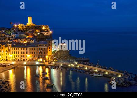 Italien, Cinque Terre, Vernazza. Stadt und Bucht beleuchtet in der Nacht. Stockfoto