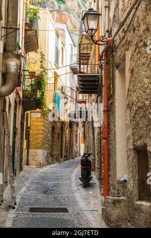 Italien, Sizilien, Provinz Palermo, Cefalu. Ein Roller, der auf einer schmalen Straße in der Stadt Cefalu geparkt wurde. Stockfoto