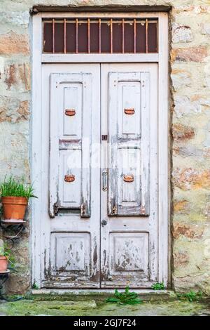 Italien, Sizilien, Provinz Palermo, Pollina. Alte Holztür auf einem Steingebäude in der Stadt Pollina. Stockfoto
