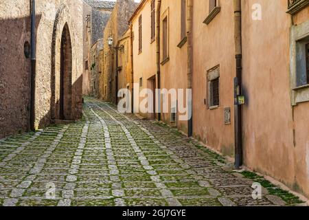 Italien, Sizilien, Provinz Trapani, Erice. Eine enge Kopfsteinpflasterstraße in der antiken Hügelstadt Erice. Stockfoto