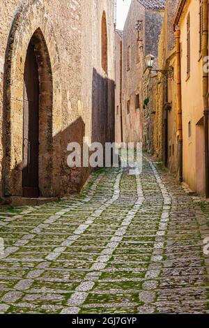 Italien, Sizilien, Provinz Trapani, Erice. Eine enge Kopfsteinpflasterstraße in der antiken Hügelstadt Erice. Stockfoto