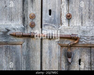 Italien, Toskana. Einzigartiges Metallschloss an einer alten Holztür. Stockfoto