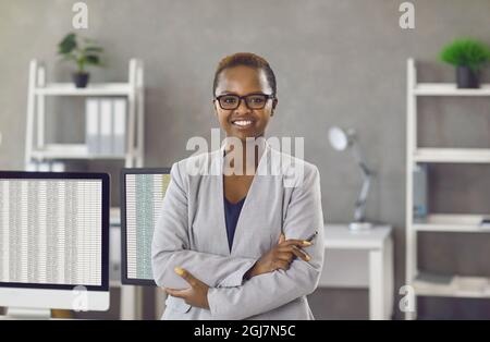 Porträt im Büro einer erfolgreichen, glücklichen dunkelhäutigen Geschäftsfrau, Managerin oder Buchhalterin. Stockfoto