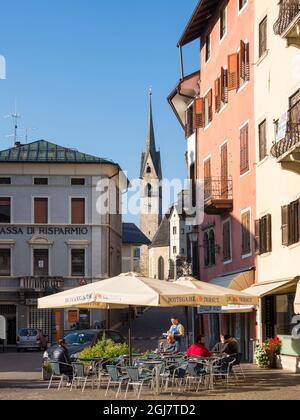 Cafe in der Fußgängerzone. Traditionelle Architektur der Fiera di Primiero im Tal von Primiero in den Dolomiten des Trentino, Italien. (Editori Stockfoto