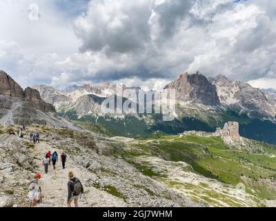 Wanderer und die Gipfel von Tofane und die Cinque Torri (Vordergrund) in den Dolomiten von Cortina d'Ampezzo. Tofane sind Teil des UNESCO-Weltkulturerbes S Stockfoto