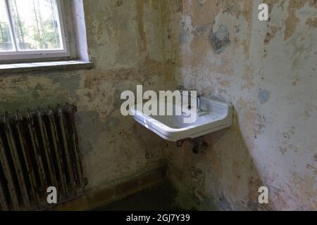 Dachau, Deutschland - 11. August 2021: Gedenkstätte des Konzentrationslagers. Im Hauptgebäude. Zimmer mit Waschbecken und Heizkörper Stockfoto