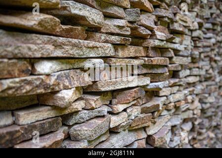 Die Wand ist mit kleinen flachen Steinen ausgekleidet. Stockfoto
