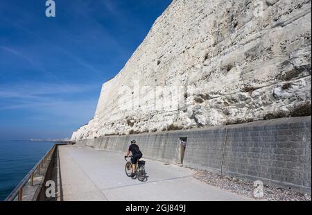 Radfahrer auf Rottingdean Klippenweg an den weißen Kreidefelsen im Sommer mit blauem Himmel in Rottingdean, an der Südküste von East Sussex, England, Großbritannien. Stockfoto