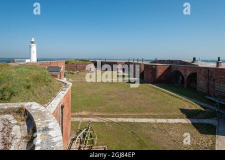 Blick auf den Ostflügel von Hurst Castle und den Leuchtturm von Hurst Point in Hampshire, England, Großbritannien Stockfoto