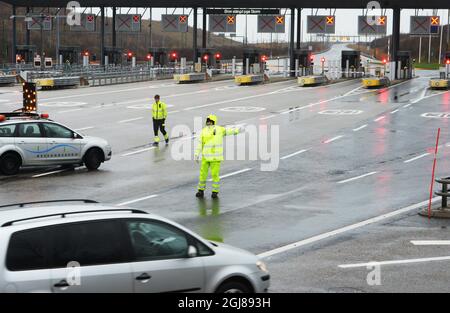 MALMÖ 2013-12-05 an einem Kontrollpunkt in Malmö, Schweden, am 5. Dezember 2013 werden Beamte in gelben Regenmänteln gesehen, die die OresundÂ-Brücke zwischen Dänemark und Schweden schließen. Der Sturm „SvenÂ“ wird voraussichtlich am Donnerstag Südschweden treffen. Foto: Johan Nilsson / TT / Kod 50090 Stockfoto