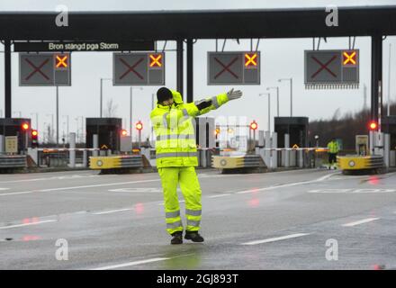 MALMO 2013-12-05 Beamte in gelben Regenmänteln werden gesehen, wie sie die OresundÃ¢Â € Â™s Brücke zwischen Dänemark und Schweden an einem Kontrollpunkt in Malmo, Schweden, am 5. Dezember 2013 schließen. Der Sturm „SvenÃ¢Â € Â wird voraussichtlich Südschweden während Donnerstag treffen. Foto: Johan Nilsson / TT / Kod 50090 Stockfoto