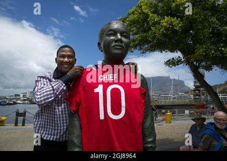 Kapstadt , Südafrika 9. Januar 2013. Chief Mandela, der Enkel von Nelson Mandela, bekam ein norwegisches Fußballtrikot als Geschenk von der norwegischen Fußballnationalmannschaft. Stolz zeigte er es allen, indem er es auf die Statue seines Großvaters Nelson Mandela in Kapstadt setzte. Später an diesem Tag besuchte die norwegische Fußballmannschaft Robben Island, wo Nelson Mandela 18 Jahre lang inhaftiert war. Foto: Heiko Junge / NTB SCANPIX Stockfoto