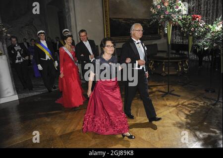 STOCKHOLM 2013-12-10 Schwedens König Carl Gustaf und Mira Nikomarow, Ehefrau des Nobelpreisträgers Professor Francois Englert, gefolgt von Schwedens Königin Silvia und Carl-Henrik Heldin, dem Leiter des Nobel-Stiftungsrats, Ankunft in der „Prince's Gallery“ im Stockholmer Rathaus nach dem Abendessen beim traditionellen Nobelpreis-Gala-Bankett am 10. Dezember 2013. Foto: Erik Martensson / TT / Code 10400 Stockfoto