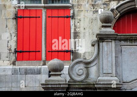 Europa, Niederlande, Den Haag. Rotes Fenster mit Fensterläden und Steinrolle auf dem alten Rathaus aus dem 16. Jahrhundert. Stockfoto