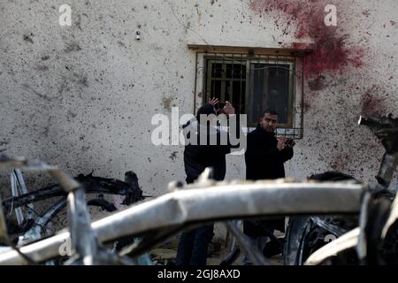 Gaza 2014-01-22 Gaza, Palästinensische Autonomiegebiete. 22. Januar 2014 -- Palästinenser betrachten Blutflecken an der Wand eines Hauses bei einem israelischen Luftangriff in Beit Hanoun im nördlichen Gazastreifen. Israel tötete am Mittwoch bei einem Luftangriff zwei Militante in Gaza. -- Palästinenser versammeln sich neben einem zerstörten Auto, nachdem es von einem israelischen Luftangriff in Beit Hanun im nördlichen Gazastreifen getroffen wurde, bei dem zwei palästinensische Mitglieder des Islamischen Jihad getötet wurden. Foto yazan majdi / Demotix / Demotix / TT / kod 10535 ** Stockfoto