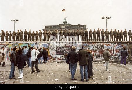 BERLIN-AKTE 1989-11-14 Eine Menschenmenge vor der Berliner Mauer nach West-Berlin, Westdeutschland, 14. November 1989, die DDR-Grenzsoldaten stehen an der Mauer vor dem Brandenburger Tor in Verbindung mit dem Mauerfall. Foto: Peter Diedrich / SVD / TT / Code: 11014 Stockfoto