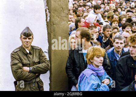 BERLIN DATEI 1989-11-14 ein DDR-Soldat beobachtet die Menschenmassen, wenn die Mauer in der Bernauer Straße in Ostberlin, 14. November 1989 im Zusammenhang mit dem Mauerfall geöffnet wird. Foto: Peter Diedrich / SVD / TT / Code: 11014 Stockfoto