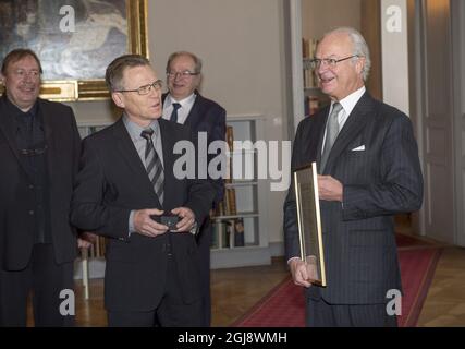 STOCKHOLM 20141118 König Carl Gustaf ist gut gelaunt, als Kristinn Johannesson aus Island im Königspalast von Stockholm aus den Sagas der Isländer reeds. Der isländische Botschafter Gunnar Gunnarsson und eine Delegation überreichten bei einer Audienz mit König Carl Gustaf eine neue Übersetzung von fünf Einbänden der Sagas der Isländer. Foto: Fredrik Sandberg / TT / kod 10080 Stockfoto