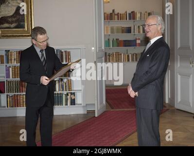 STOCKHOLM 20141118 König Carl Gustaf ist gut gelaunt, als Kristinn Johannesson aus Island im Königspalast von Stockholm aus den Sagas der Isländer reeds. Der isländische Botschafter Gunnar Gunnarsson und eine Delegation überreichten bei einer Audienz mit König Carl Gustaf eine neue Übersetzung von fünf Einbänden der Sagas der Isländer. Foto: Fredrik Sandberg / TT / kod 10080 Stockfoto