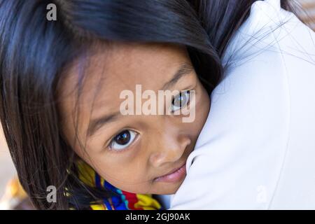 Ein kleines asiatisches Mädchen umarmt seine Mutter mit Liebe und Wärme zwischen Mutter und Kind. Stockfoto