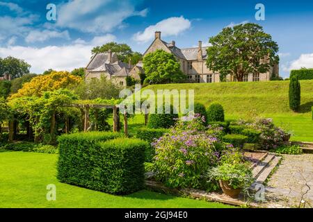 Die farbenfrohen Grenzen und das Topiary im italienischen Fountain Court Garten im Mapperton House, Dorset, England, Großbritannien Stockfoto