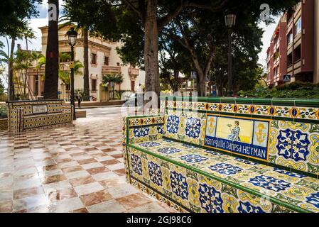 Spanien, Kanarische Inseln, Teneriffa, Santa Cruz de Tenerife, Plaza 25 de Julio, Anfang des 20. Jahrhunderts Park mit Bänken in den antiken Werbung abgedeckt Stockfoto