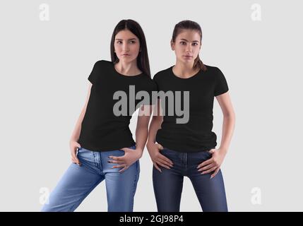 Schwarzes Paar T-Shirt Vorlage auf posiert Mädchen in Jeans, modische Damenbekleidung für Design, Werbung. Mockup von leeren сouple Kleidung für Druck, Stockfoto